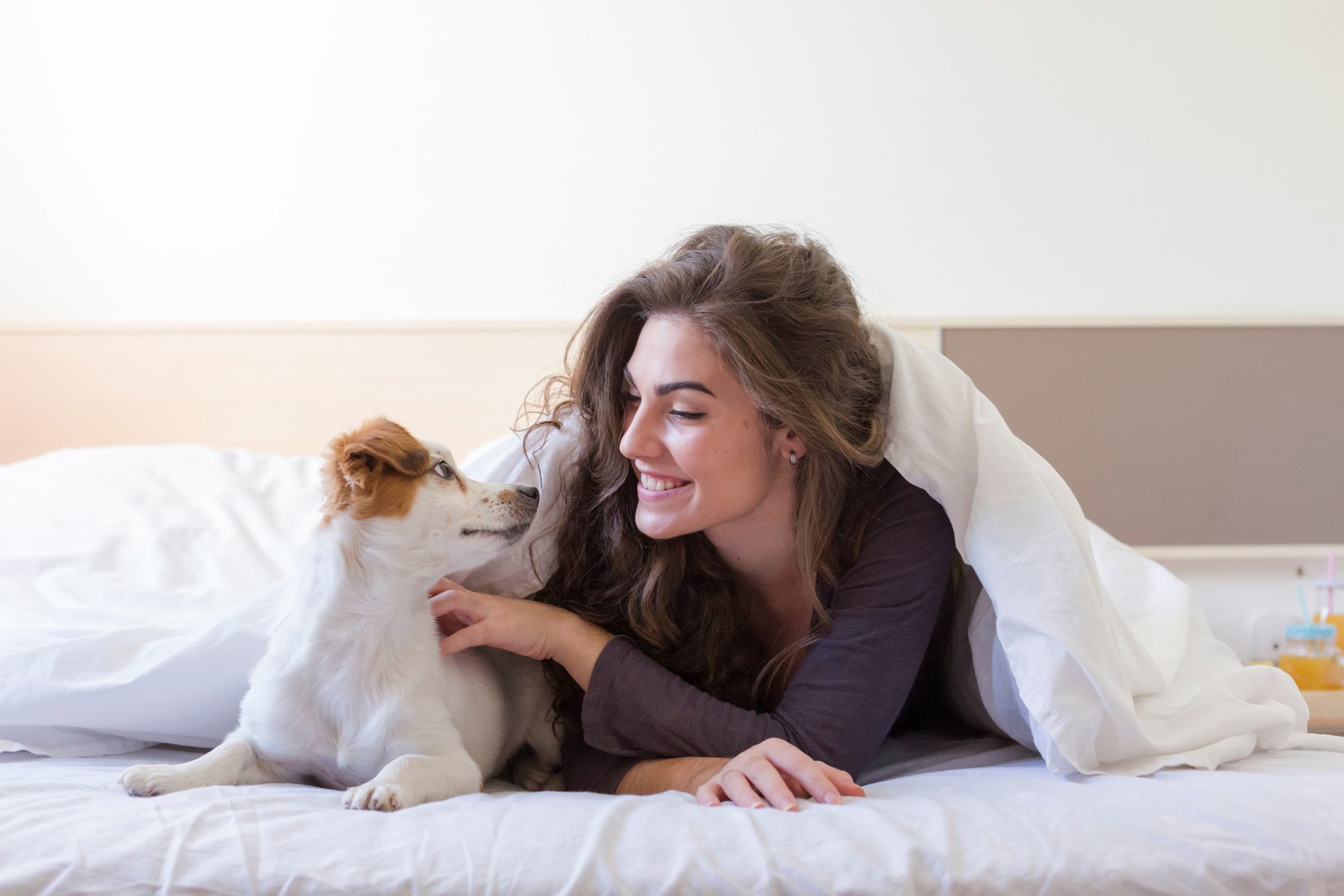 Woman with Pet Dog in Bed